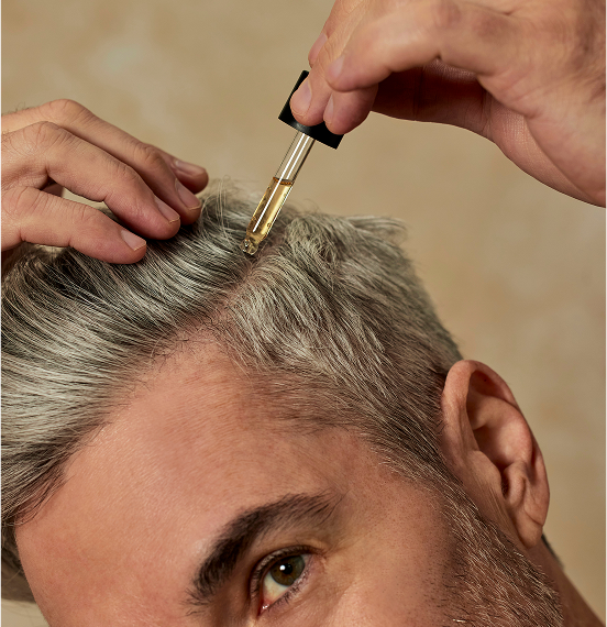 Man applying serum to scalp